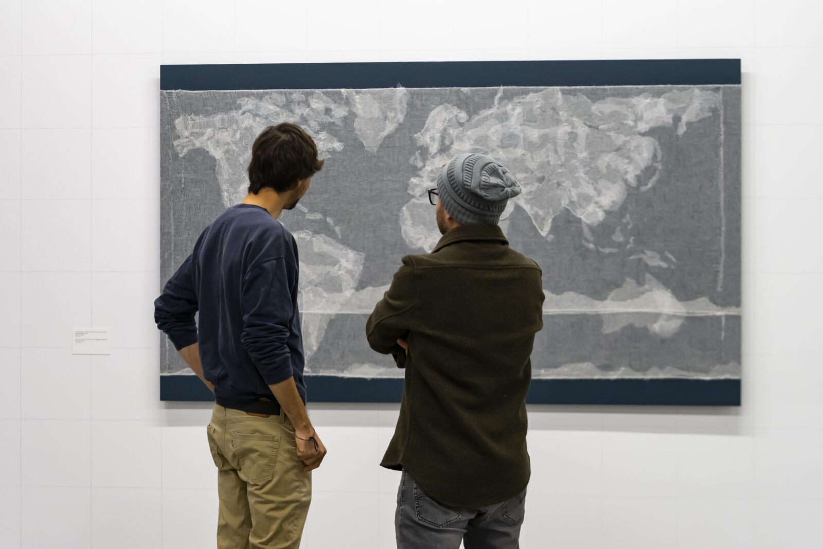 2 people looking at artwork of a map
