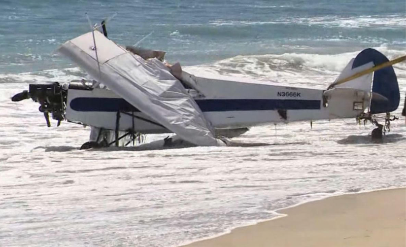 small plane on beach with wrecked wings
