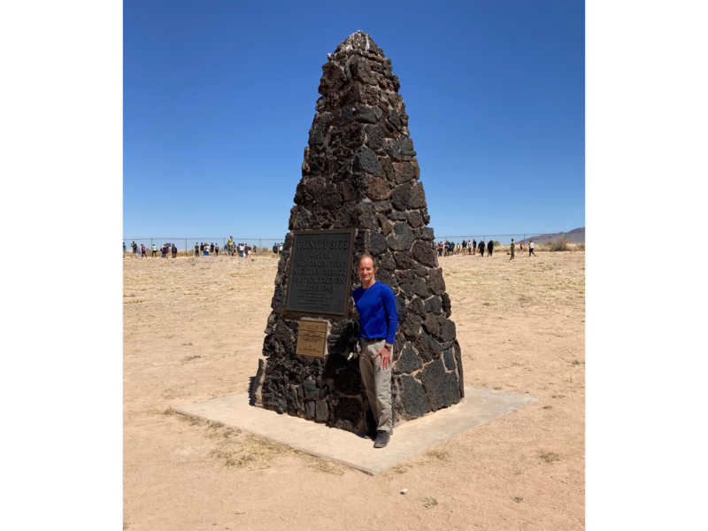 man standing next to monument made out of rock