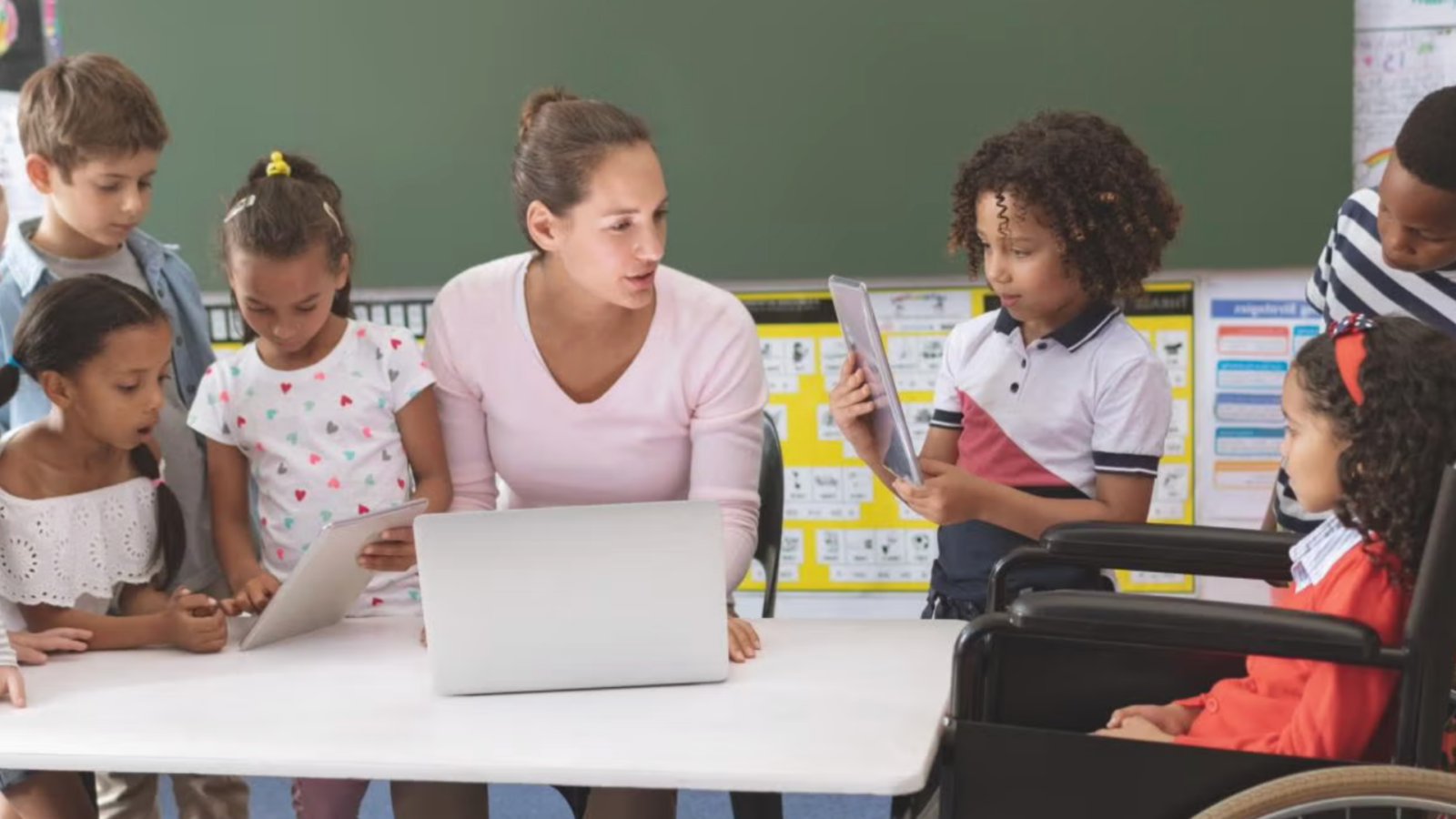 Woman sitting with children in a classroom.